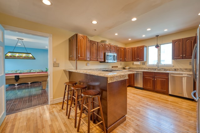 7 Crescent Ave, East Lyme, CT 06357 - kitchen featuring stainless steel appliances, a kitchen bar, a peninsula, light wood-style floors, and recessed lighting
