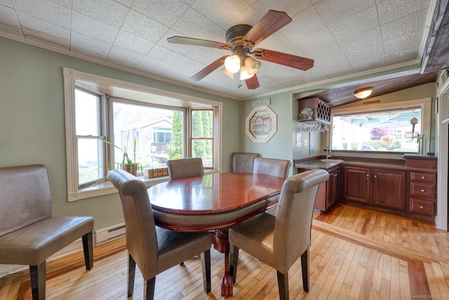 7 Crescent Ave, East Lyme, CT 06357 - dining room featuring a baseboard heating unit, light wood-style floors, ornamental molding, healthy amount of natural light, and a ceiling fan