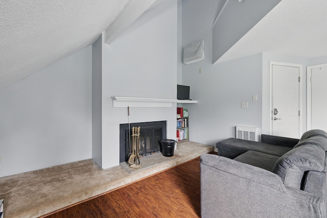 22 River Colony, Guilford, CT 06437 - living room with a textured ceiling, wood finished floors, a fireplace with raised hearth, and vaulted ceiling