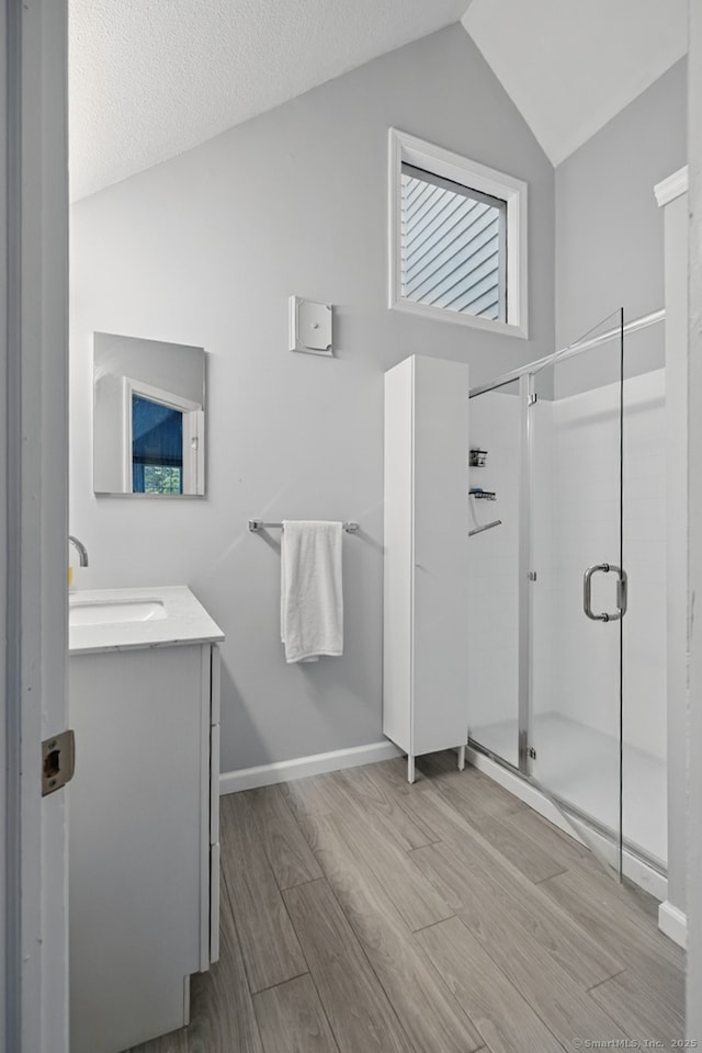 22 River Colony, Guilford, CT 06437 - bathroom featuring wood finished floors, vanity, a stall shower, and vaulted ceiling