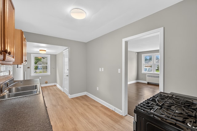 6 Crescent Dr, Danbury, CT 06810 - kitchen featuring range with gas cooktop, brown cabinets, light wood-style flooring, and radiator