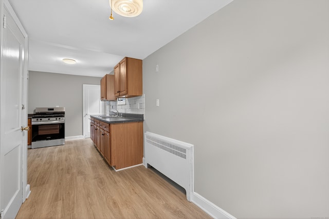6 Crescent Dr, Danbury, CT 06810 - kitchen with stainless steel range with gas cooktop, radiator, brown cabinets, and light wood finished floors