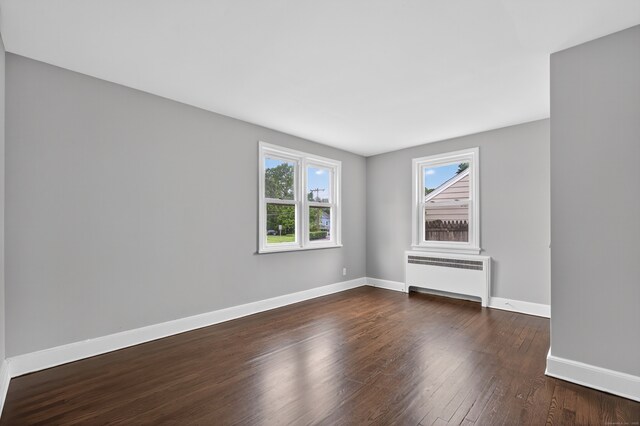 6 Crescent Dr, Danbury, CT 06810 - unfurnished room featuring radiator heating unit, plenty of natural light, and wood-type flooring