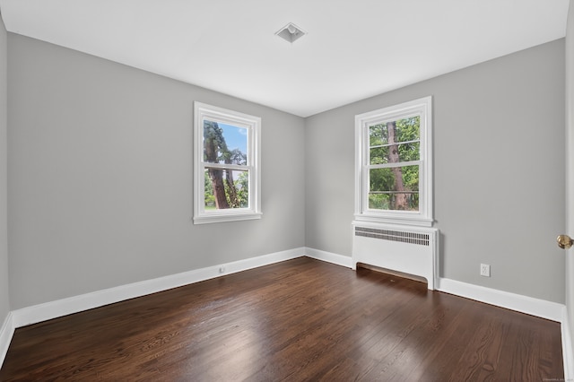 6 Crescent Dr, Danbury, CT 06810 - empty room with radiator heating unit, healthy amount of natural light, and dark wood-style flooring