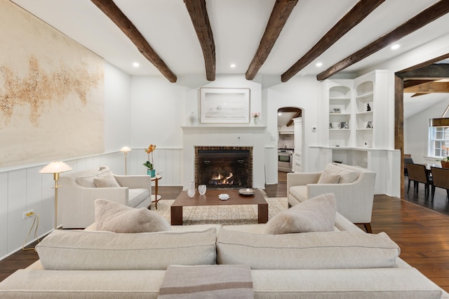47 Godfrey Rd W, Weston, CT 06883 - living area with arched walkways, dark wood-type flooring, a warm lit fireplace, recessed lighting, and wainscoting