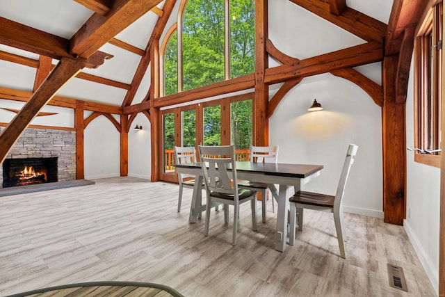 122 Old Post Rd, Old Saybrook, CT 06475 - dining area with wood finished floors, a stone fireplace, high vaulted ceiling, and beamed ceiling
