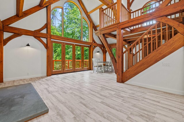 122 Old Post Rd, Old Saybrook, CT 06475 - unfurnished living room featuring high vaulted ceiling, stairs, and wood finished floors