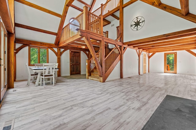 122 Old Post Rd, Old Saybrook, CT 06475 - unfurnished living room with high vaulted ceiling, stairway, wood finished floors, and beamed ceiling