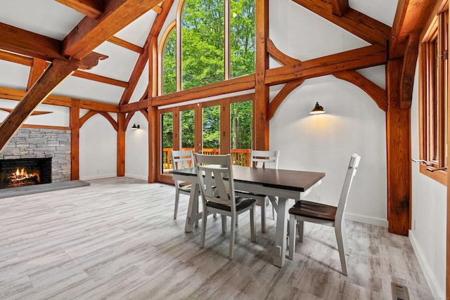 122 Old Post Rd, Old Saybrook, CT 06475 - dining room featuring a stone fireplace, wood finished floors, high vaulted ceiling, and beam ceiling