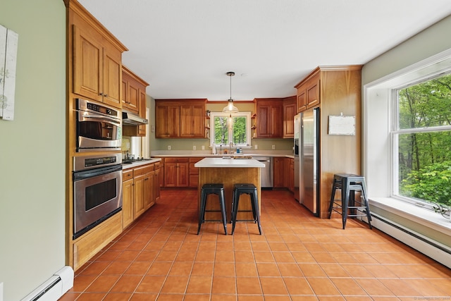 65 Nassahegan Dr, Burlington, CT 06013 - kitchen featuring a baseboard radiator, stainless steel appliances, light tile patterned floors, light countertops, and a center island