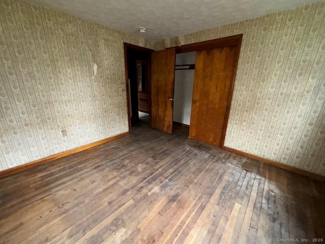 4 Lox Ln, Enfield, CT 06082 - unfurnished bedroom with hardwood / wood-style floors, a closet, and a textured ceiling