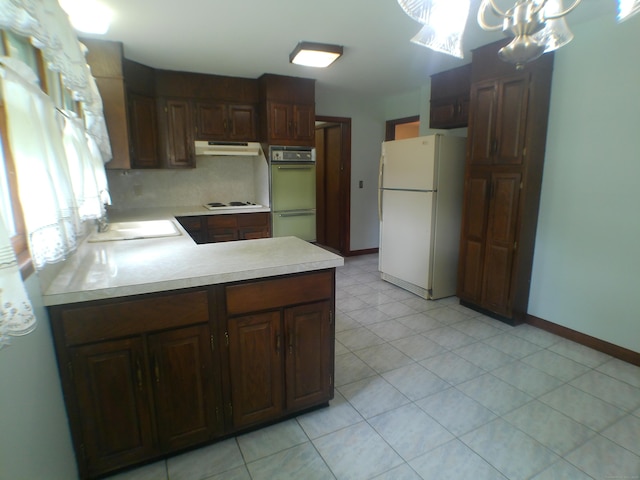 152 Old Mill Rd, Middletown, CT 06457 - kitchen with white appliances, under cabinet range hood, light countertops, a peninsula, and a chandelier