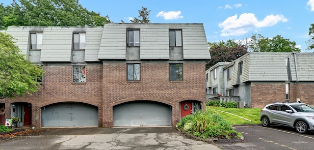 70 Trolley Crossing Ln Unit 70, Middletown, CT 06457 - view of front of property featuring brick siding, an attached garage, mansard roof, and driveway