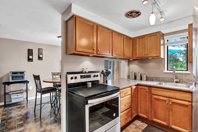70 Trolley Crossing Ln Unit 70, Middletown, CT 06457 - kitchen featuring stainless steel electric stove, brown cabinets, and rail lighting