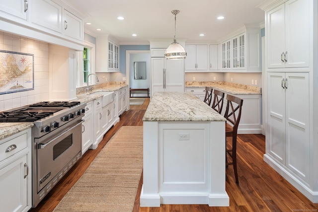 37 Woodridge Cir, New Canaan, CT 06840 - kitchen featuring high end appliances, a kitchen island, white cabinets, dark wood-type flooring, and ornamental molding