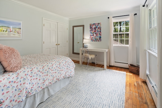 37 Woodridge Cir, New Canaan, CT 06840 - bedroom with baseboard heating, crown molding, light wood-style flooring, and a closet