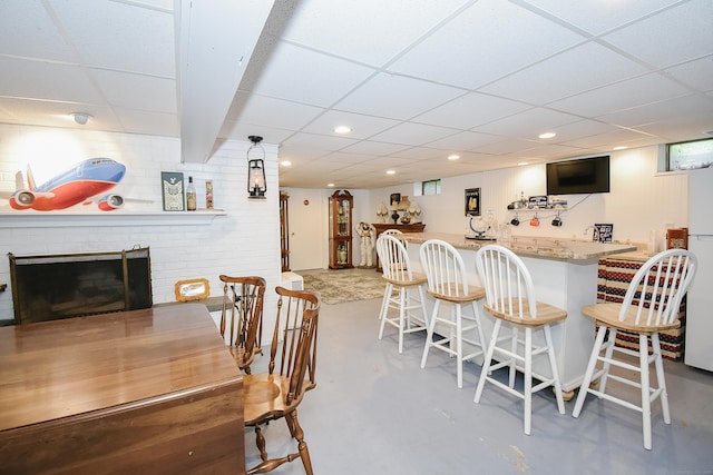 100 Ridgebrook Rd, Torrington, CT 06790 - dining room featuring a paneled ceiling, concrete flooring, bar area, a fireplace, and recessed lighting