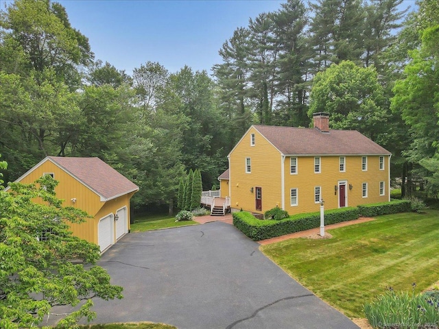 47 Cricket Ln, Somers, CT 06071 - view of side of home featuring a detached garage, an outbuilding, a lawn, and a chimney