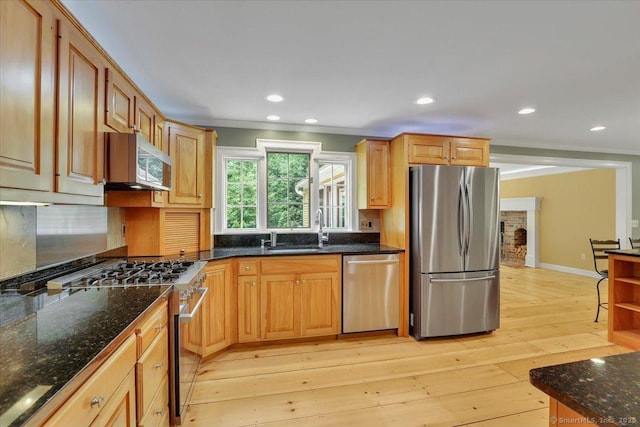 47 Cricket Ln, Somers, CT 06071 - kitchen with appliances with stainless steel finishes, ornamental molding, light wood-type flooring, backsplash, and dark stone counters