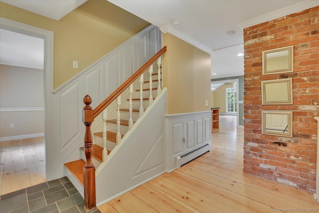 47 Cricket Ln, Somers, CT 06071 - stairway with a baseboard heating unit, a decorative wall, hardwood / wood-style flooring, a wainscoted wall, and crown molding