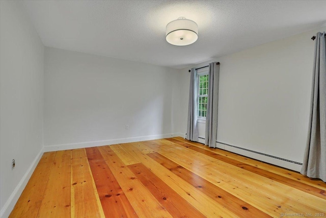 47 Cricket Ln, Somers, CT 06071 - unfurnished room with a baseboard heating unit, baseboards, light wood-style flooring, and a textured ceiling