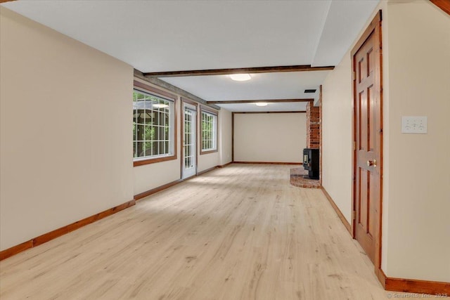47 Cricket Ln, Somers, CT 06071 - unfurnished room featuring baseboards, light wood-style floors, beam ceiling, and a wood stove