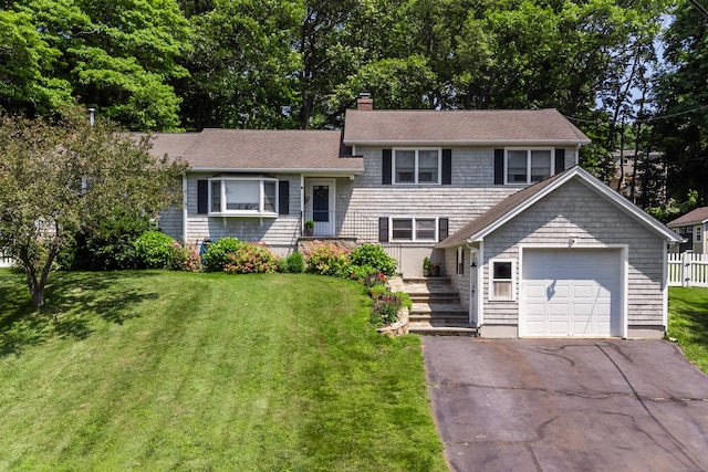 31 Wildwood Dr, Branford, CT 06405 - tri-level home featuring a chimney, a garage, and a front yard