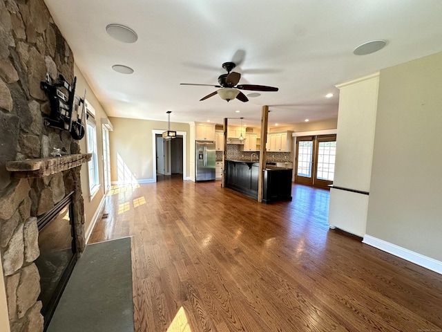 57 Church St, Shelton, CT 06484 - unfurnished living room featuring a stone fireplace, ceiling fan, and dark wood finished floors