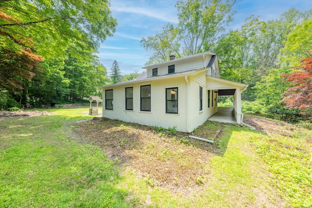 219 Redding Rd, Redding, CT 06896 - view of home's exterior with a lawn, a chimney, and stucco siding