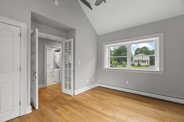75 Harrison Ave, Wallingford, CT 06492 - unfurnished bedroom with stacked washer / drying machine, a baseboard radiator, light wood finished floors, and lofted ceiling
