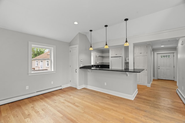 75 Harrison Ave, Wallingford, CT 06492 - kitchen with freestanding refrigerator, a baseboard heating unit, a breakfast bar, light wood-style flooring, and a peninsula