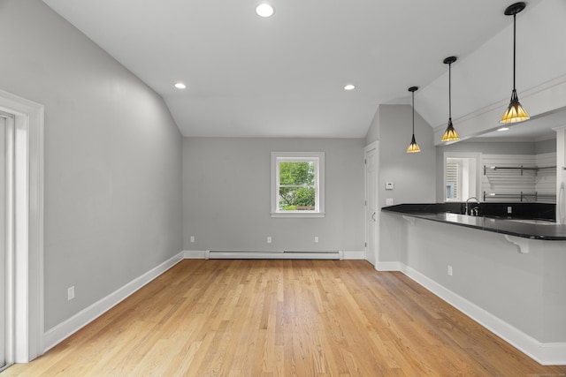 75 Harrison Ave, Wallingford, CT 06492 - kitchen with a baseboard heating unit, lofted ceiling, wood finished floors, a breakfast bar area, and dark countertops