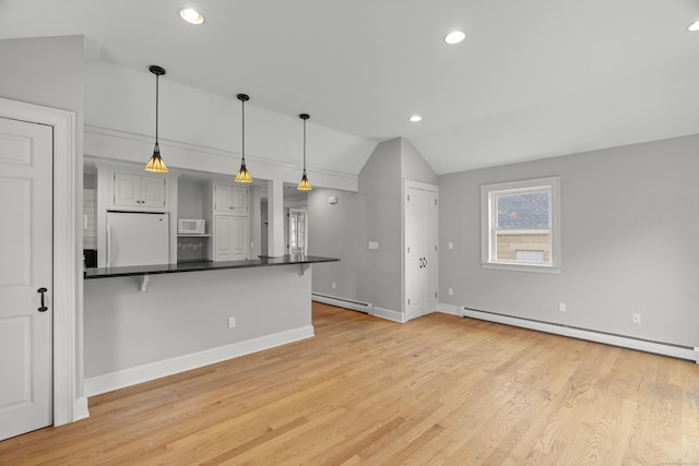 75 Harrison Ave, Wallingford, CT 06492 - kitchen featuring white appliances, baseboard heating, lofted ceiling, dark countertops, and a breakfast bar