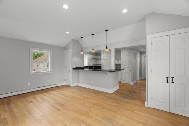 75 Harrison Ave, Wallingford, CT 06492 - kitchen with lofted ceiling, white refrigerator, dark countertops, a peninsula, and light wood-type flooring