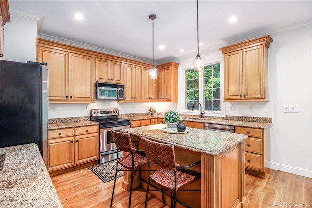 22 Woods Way Unit 22, Redding, CT 06896 - kitchen with stainless steel appliances, ornamental molding, light wood-style floors, a breakfast bar, and a center island