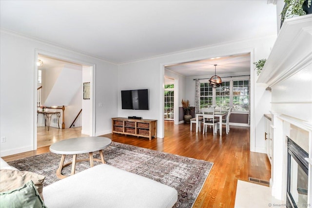 22 Woods Way Unit 22, Redding, CT 06896 - living area with wood finished floors, ornamental molding, a fireplace with flush hearth, and a chandelier