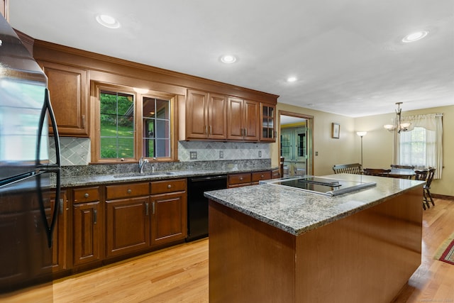 389 Chamberlain Rd, Middletown, CT 06457 - kitchen with black appliances, light wood-style floors, a kitchen island, dark stone countertops, and recessed lighting