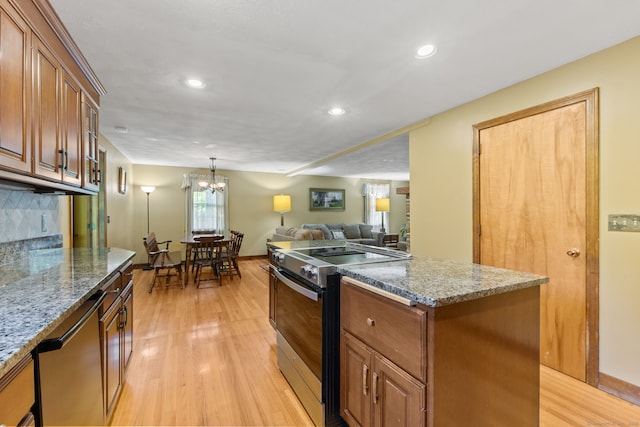 389 Chamberlain Rd, Middletown, CT 06457 - kitchen featuring appliances with stainless steel finishes, a kitchen island, light wood finished floors, recessed lighting, and brown cabinets
