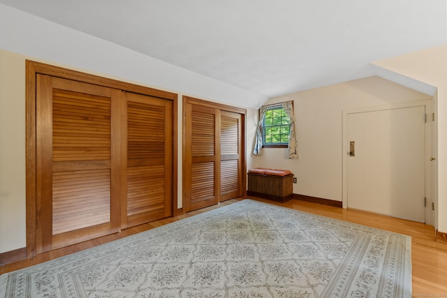 389 Chamberlain Rd, Middletown, CT 06457 - unfurnished bedroom with two closets, vaulted ceiling, and wood finished floors