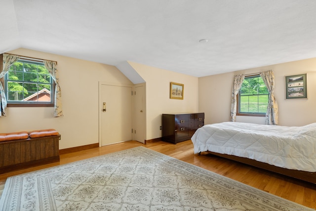 389 Chamberlain Rd, Middletown, CT 06457 - bedroom with multiple windows, light wood-type flooring, and vaulted ceiling