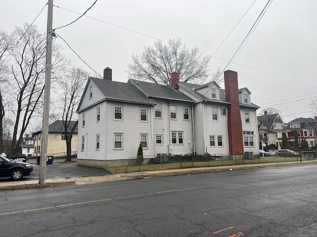 670 Clinton Ave, Bridgeport, CT 06605 - view of property exterior with a residential view, a chimney, and central AC unit