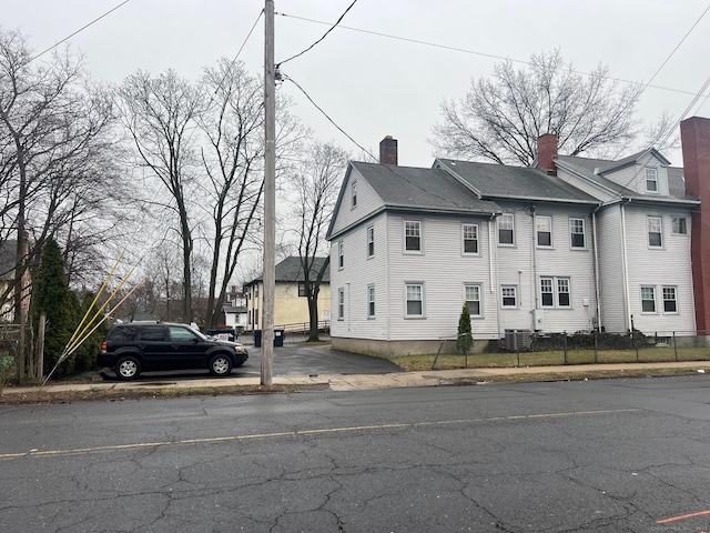 670 Clinton Ave, Bridgeport, CT 06605 - view of property exterior featuring a chimney and central AC unit