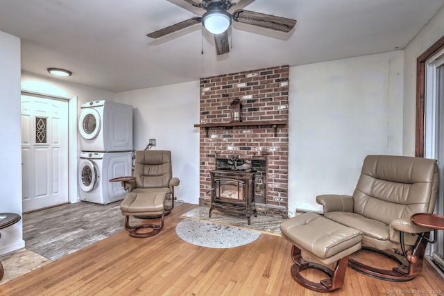17 Brush Hill Rd, Clinton, CT 06413 - living room with stacked washing machine and dryer, a ceiling fan, hardwood / wood-style floors, and a wood stove