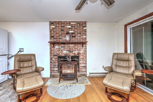 17 Brush Hill Rd, Clinton, CT 06413 - living area featuring a baseboard heating unit, a wood stove, wood-type flooring, and ceiling fan