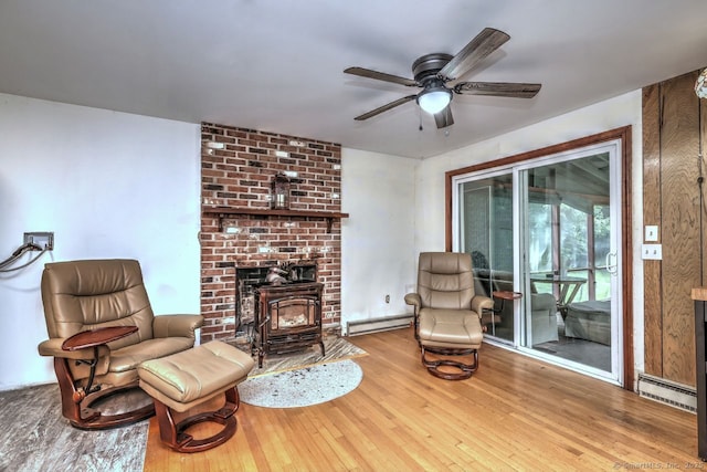 17 Brush Hill Rd, Clinton, CT 06413 - living area featuring a baseboard radiator, baseboard heating, hardwood / wood-style flooring, a ceiling fan, and a wood stove