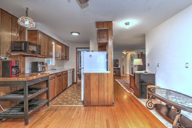 17 Brush Hill Rd, Clinton, CT 06413 - kitchen featuring black microwave, light countertops, brown cabinets, light wood-type flooring, and dishwashing machine