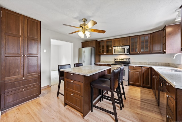1 Brook Hill Rd, Hamden, CT 06514 - kitchen featuring stainless steel appliances, a breakfast bar, light wood finished floors, ceiling fan, and a kitchen island