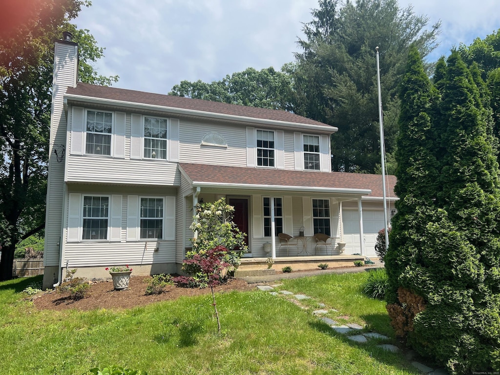 57 Walnut St, Torrington, CT 06790 - view of front of home featuring a chimney, a porch, a front yard, and an attached garage