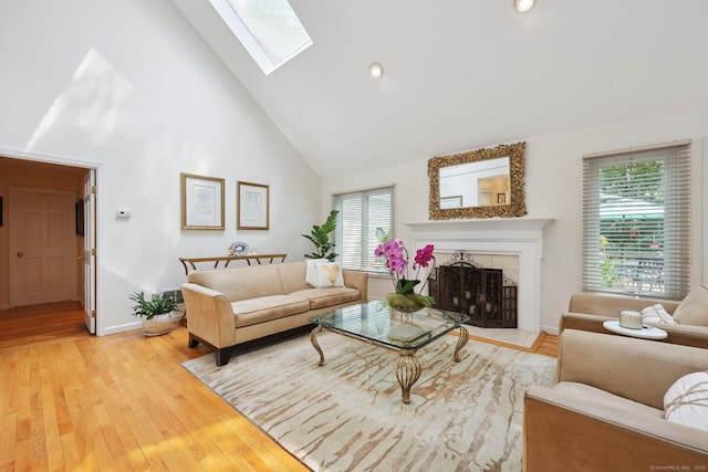 8 Highview Rd, Madison, CT 06443 - living area featuring high vaulted ceiling, healthy amount of natural light, a skylight, light wood finished floors, and a tiled fireplace