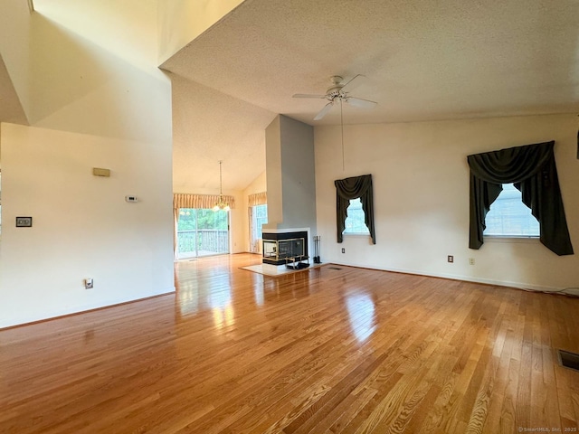 21 Rivendell Dr Unit 21, Shelton, CT 06484 - unfurnished living room featuring high vaulted ceiling, wood finished floors, a ceiling fan, a textured ceiling, and a chandelier